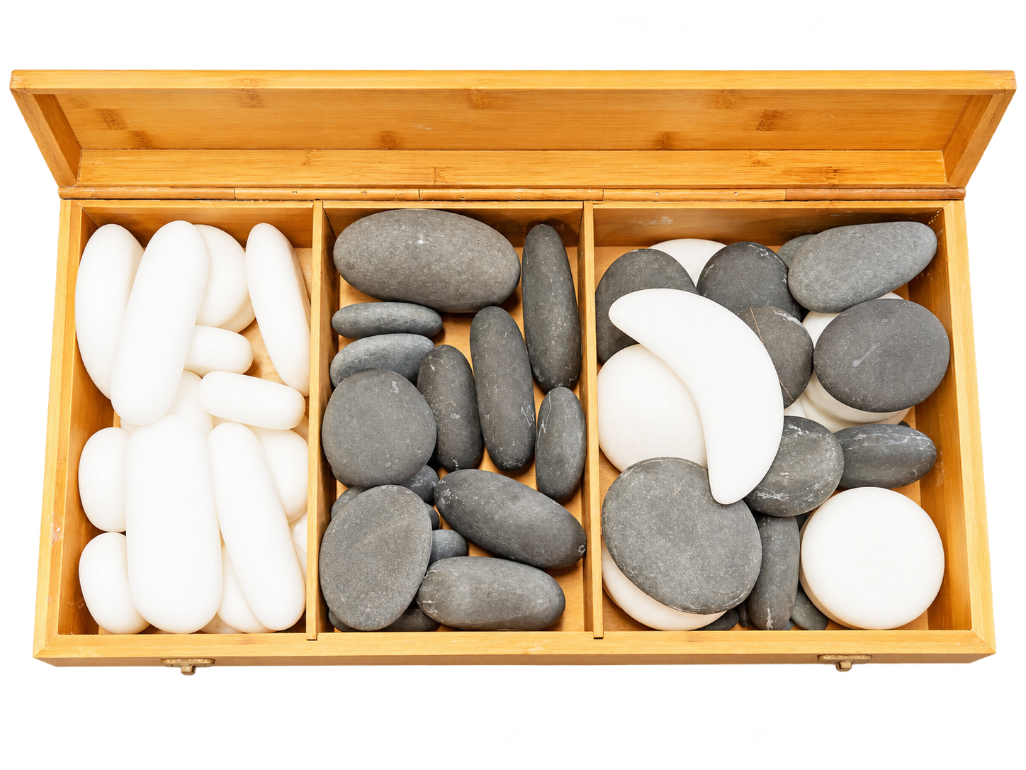 Offene Holzbox mit drei Fächern, gefüllt mit weißen und grauen Hot-Stone-Massagesteinen, von oben fotografiert