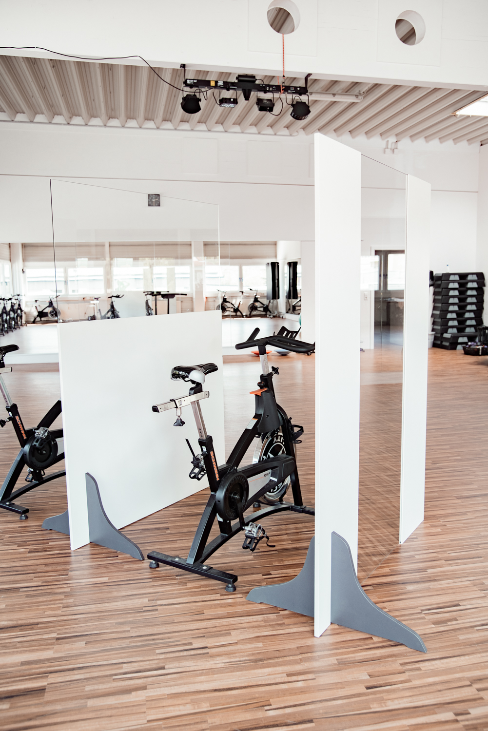 Trennwände Exclusive trennen Indoor-Cycles, im Hintergrund weitere Cycling-Reihen im Spiegel