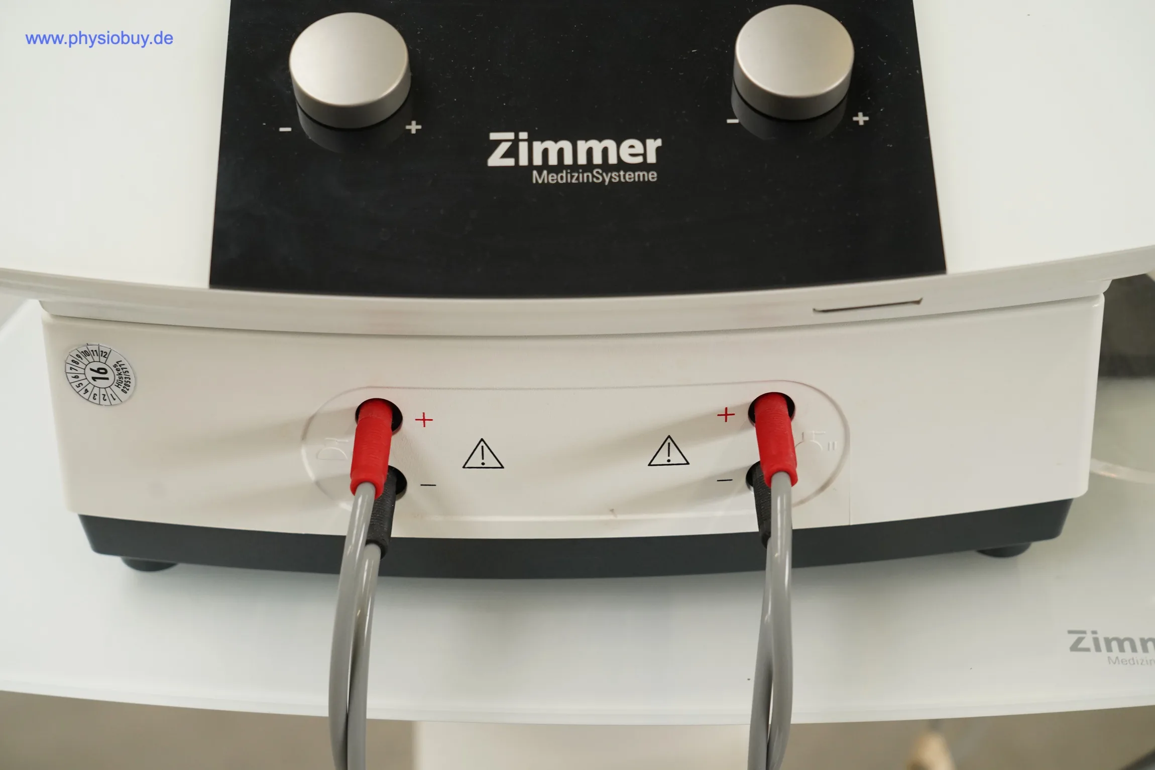 Zimmer Soleo SonoStim, Frontdetail mit zwei Drehreglern und zwei Ausgangsbuchsen mit roten Steckern und grauen Kabeln