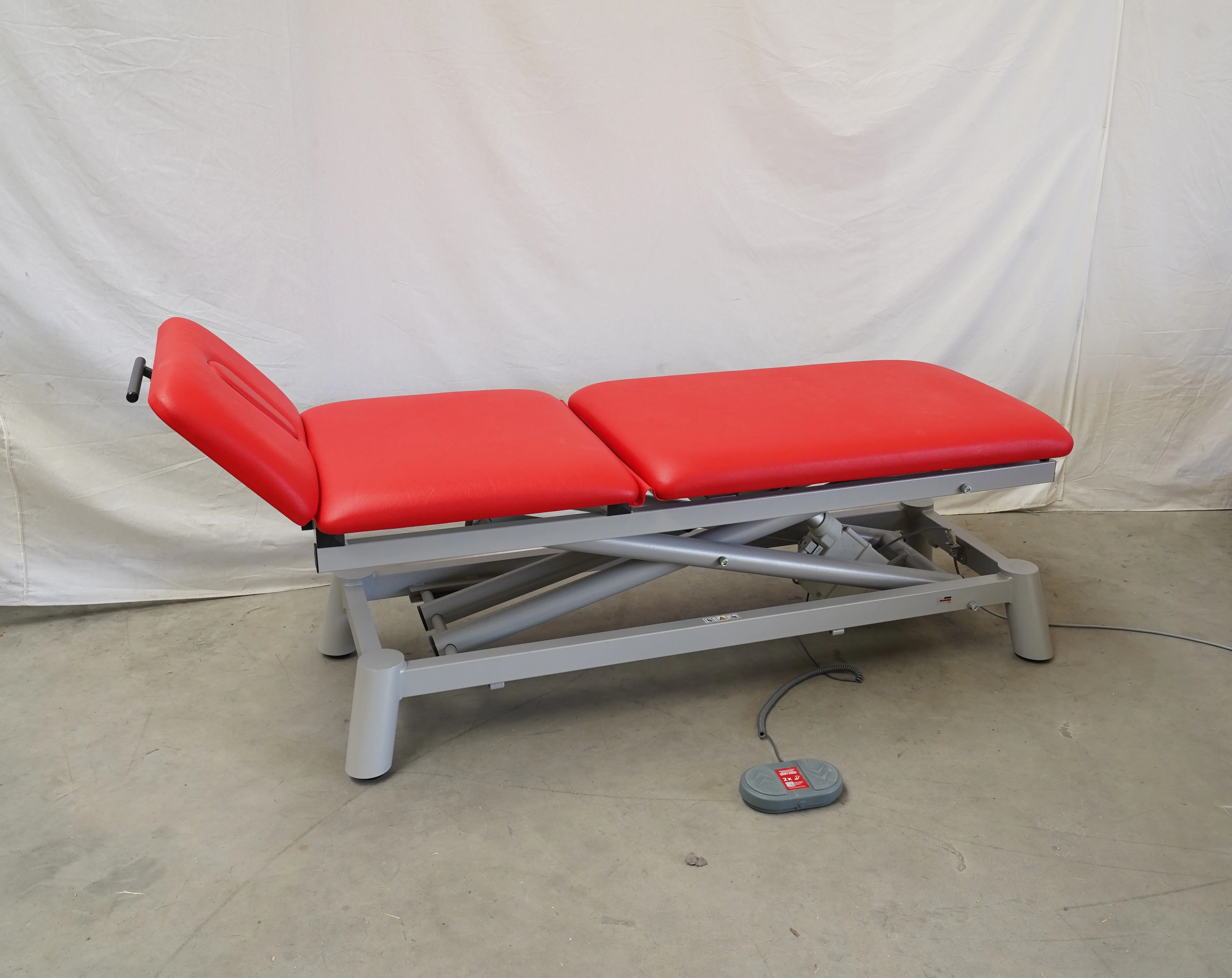 Therapieliege Pino PinoPro elektr. mit rotem Polster, auf Palette, Ansicht von vorne