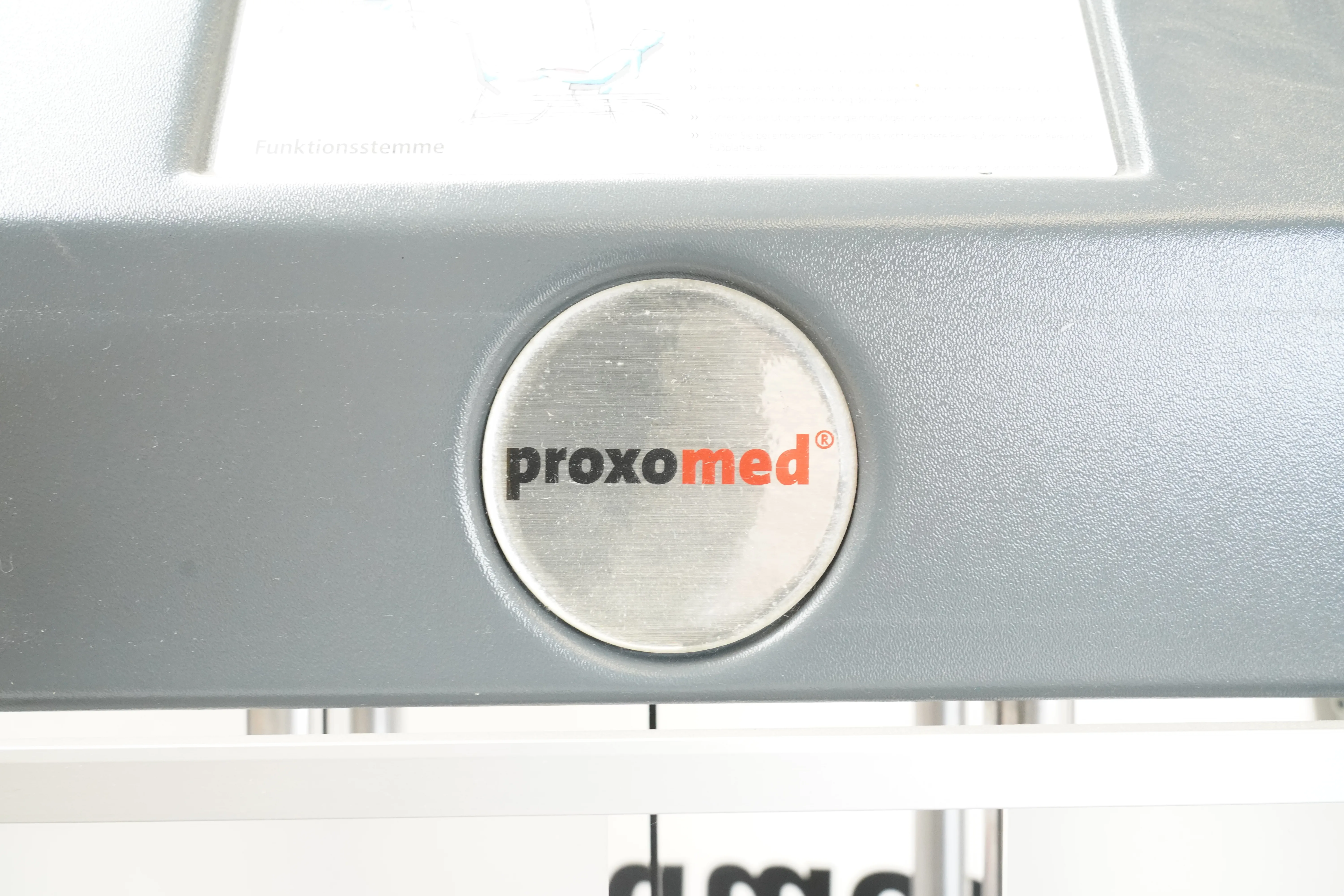 Proxomed Compass 530 KGG-Satz: Nahaufnahme des runden Proxomed-Logos auf dem grauen Kunststoffgehäuse