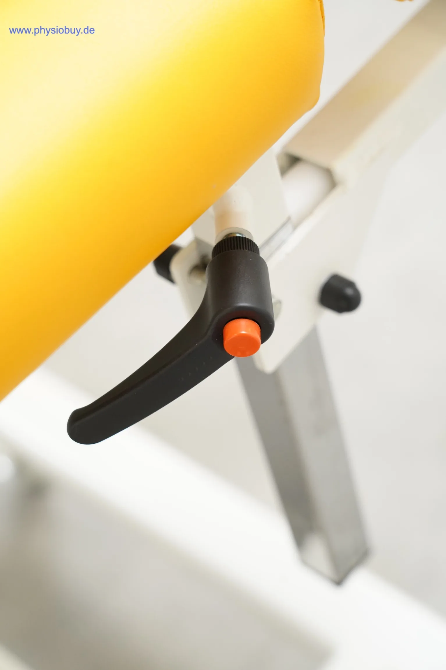 Verstellhebel mit orangem Knopf am Kopfteil der Theraflex Liege Favorite, Nahaufnahme