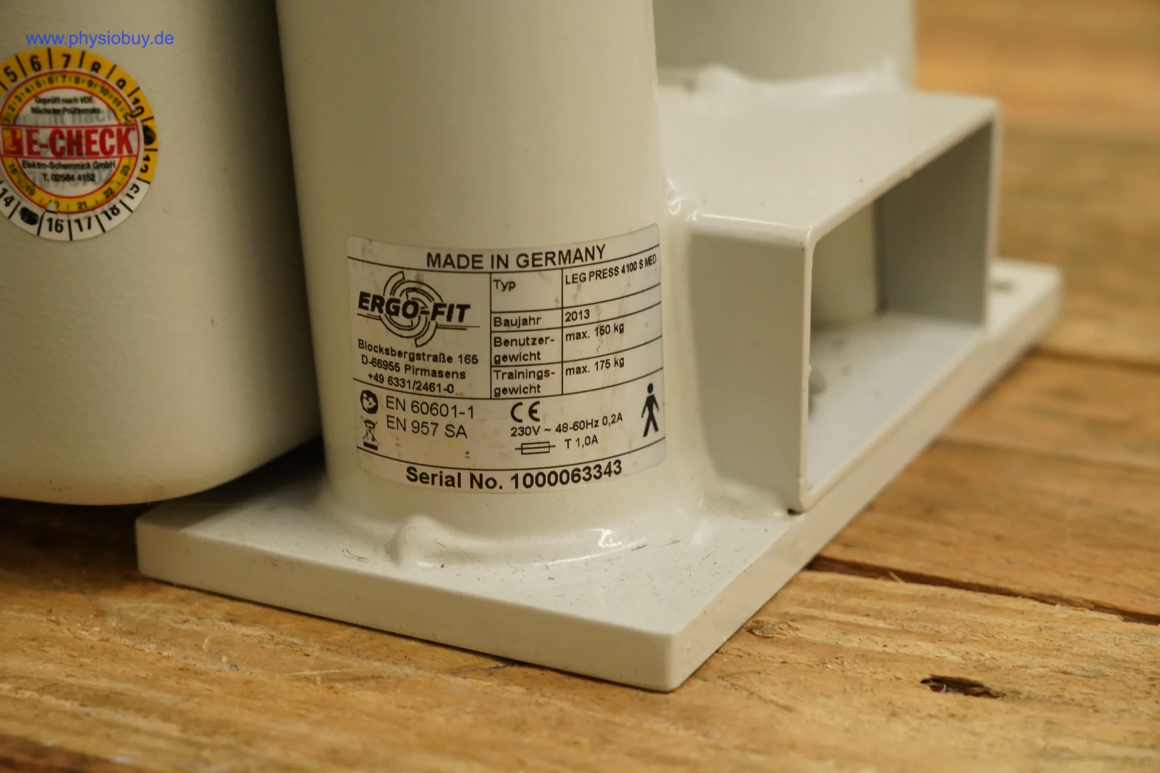 Typenschild der Ergo-Fit Beinpresse 4000 mit Seriennummer und Prüfplakette, Nahaufnahme
