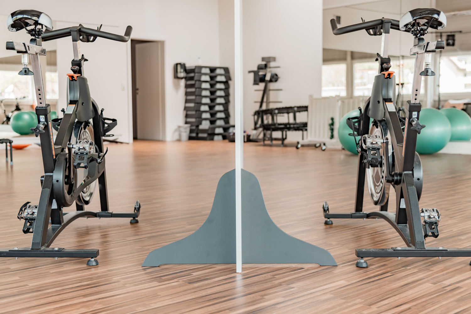 Standfuß einer Trennwand Standard zwischen zwei Indoor-Cycles im Fitnessstudio