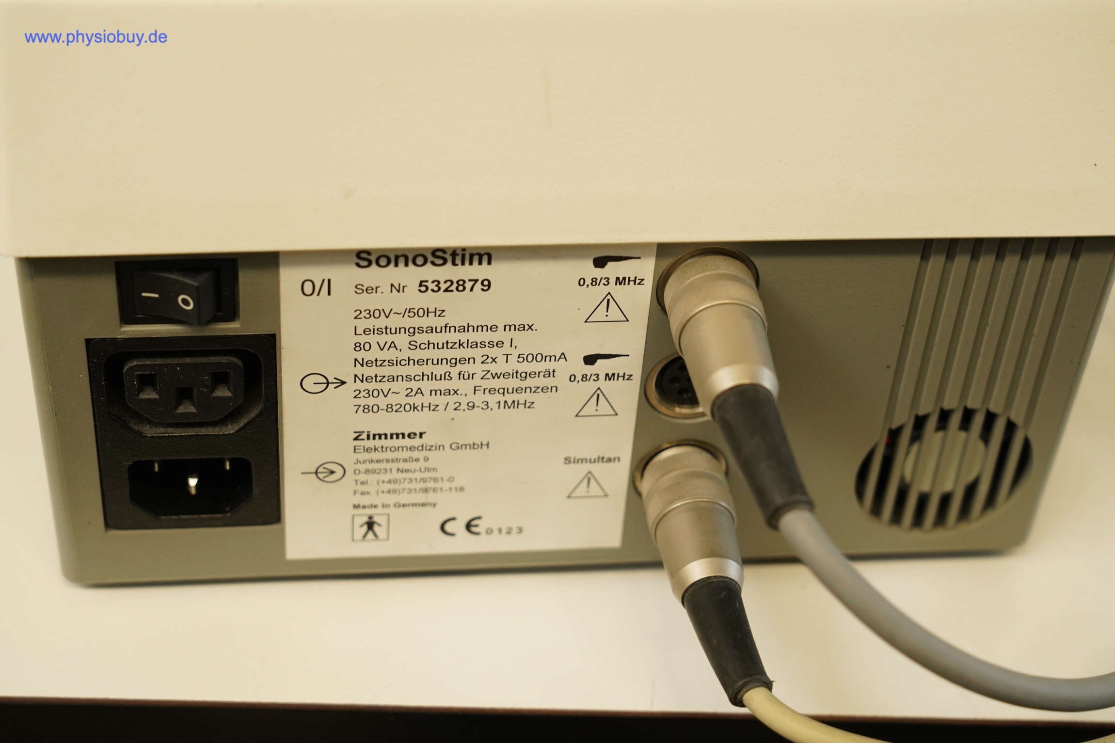 Zimmer SonoStim von hinten mit Typenschild, Netzschalter, Netzanschlüssen und zwei angeschlossenen Kabeln