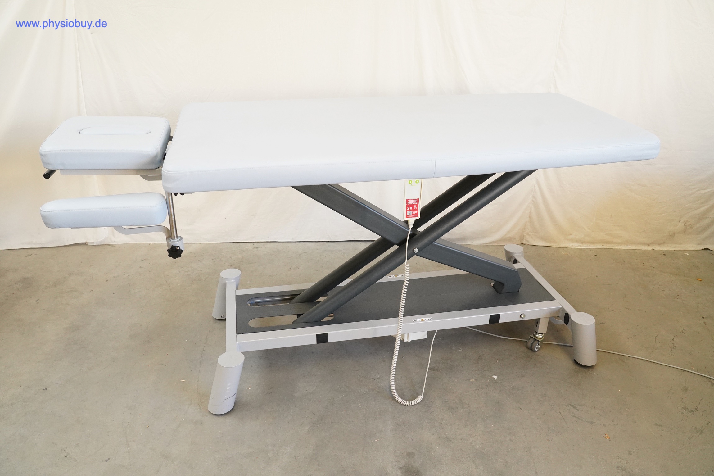 PINO XPert+ Therapieliege seitlich mit hellgrauer Polsterung, Scherenhubgestell, ausgeklapptem Kopfteil und Armablage
