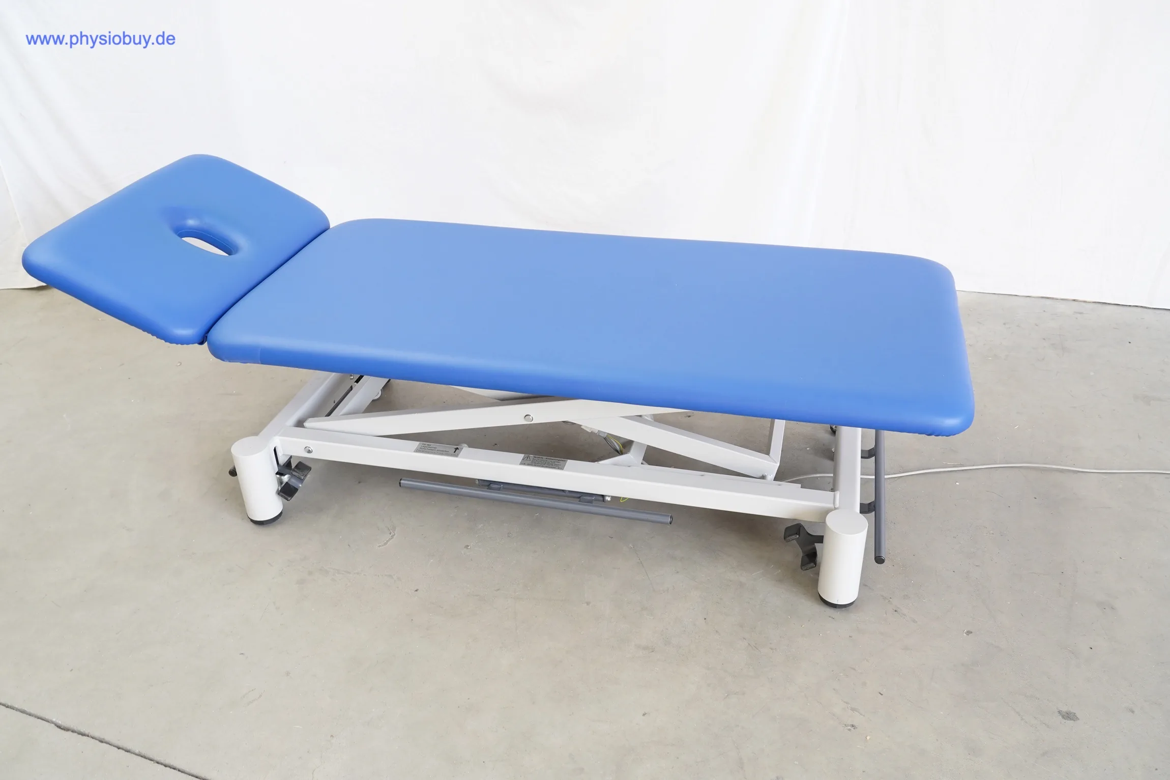Blaue Behandlungsliege FREI GYM-XII mit klappbarem Kopfteil, Ansicht von schräg vorne
