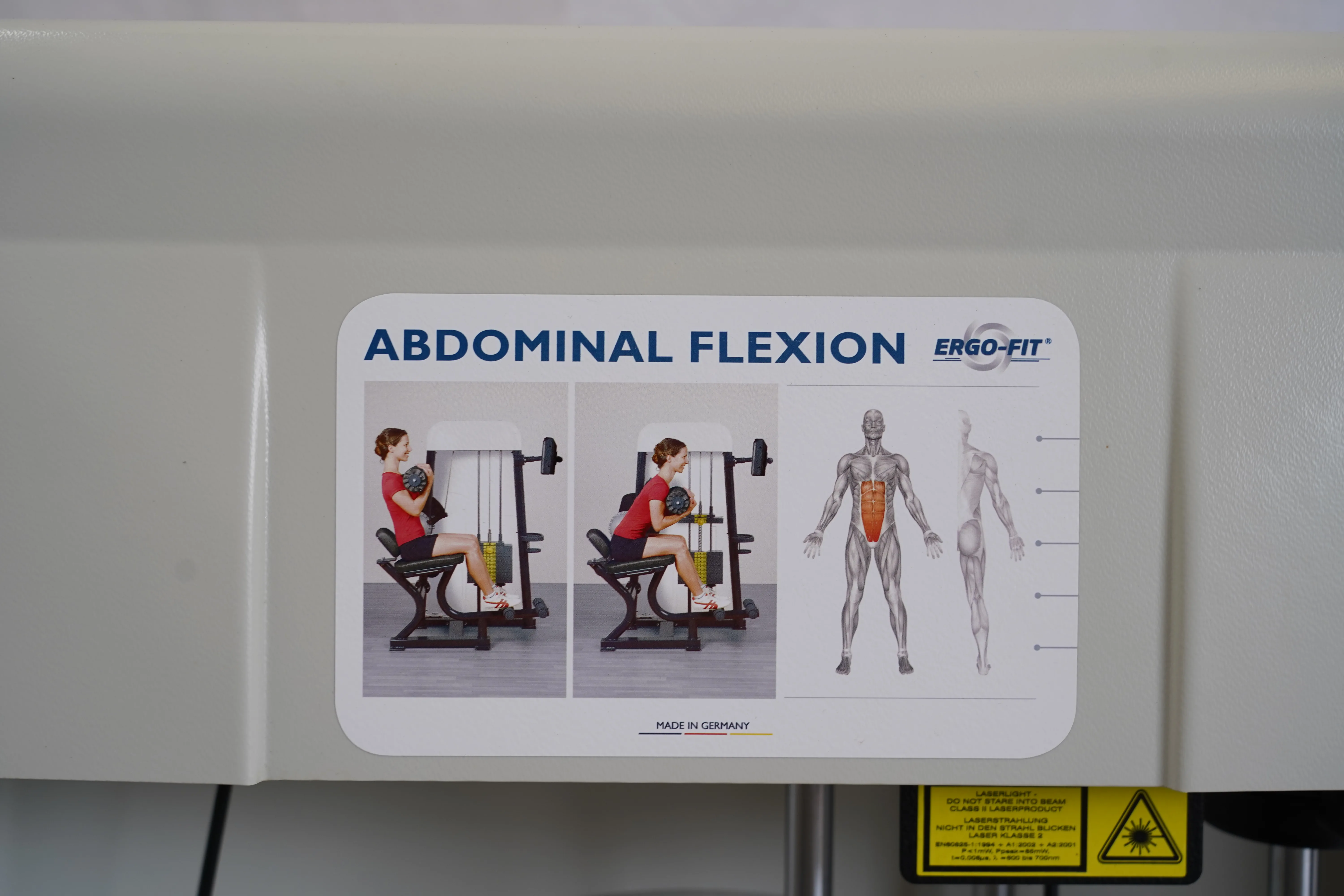 Stationsschild "Abdominal Flexion" mit Übungsdarstellung am Ergo-Fit 4100S Gerätepark