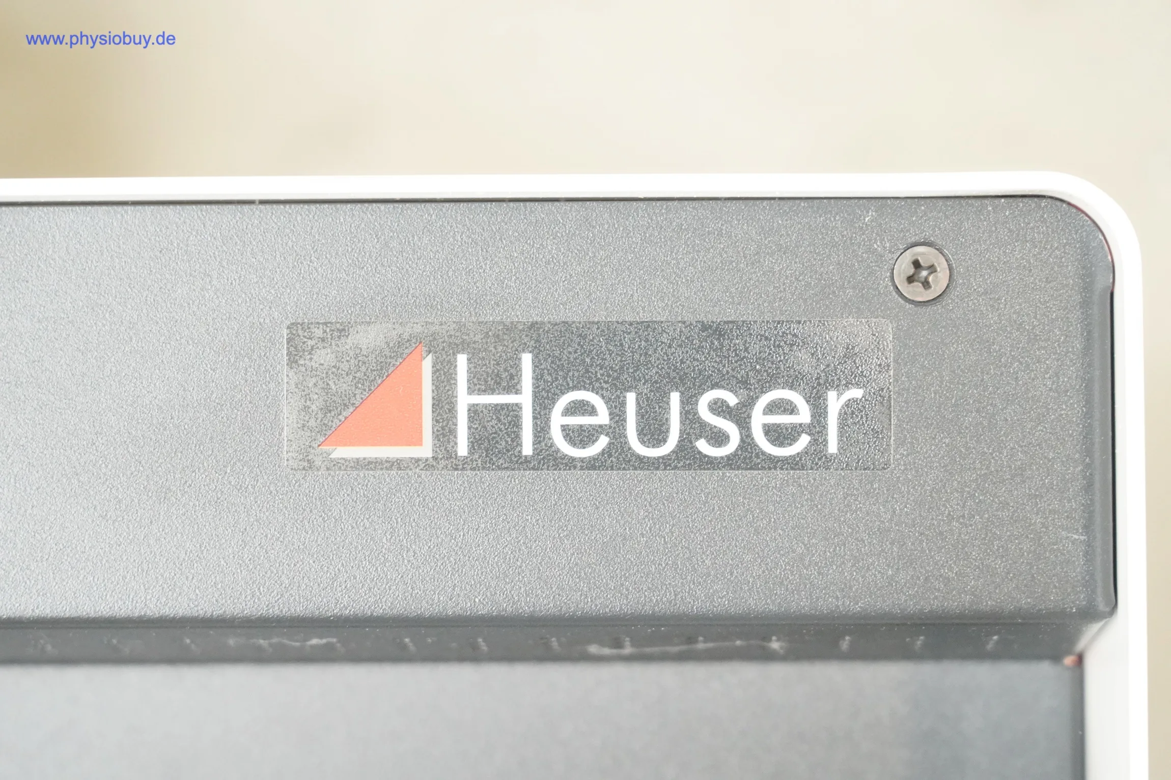 Heuser Halogen-Infrarotstrahlerkopf IRS 2 Rotlicht: Nahaufnahme des Heuser-Logos auf dem dunklen Gehäuse neben einer Schraube