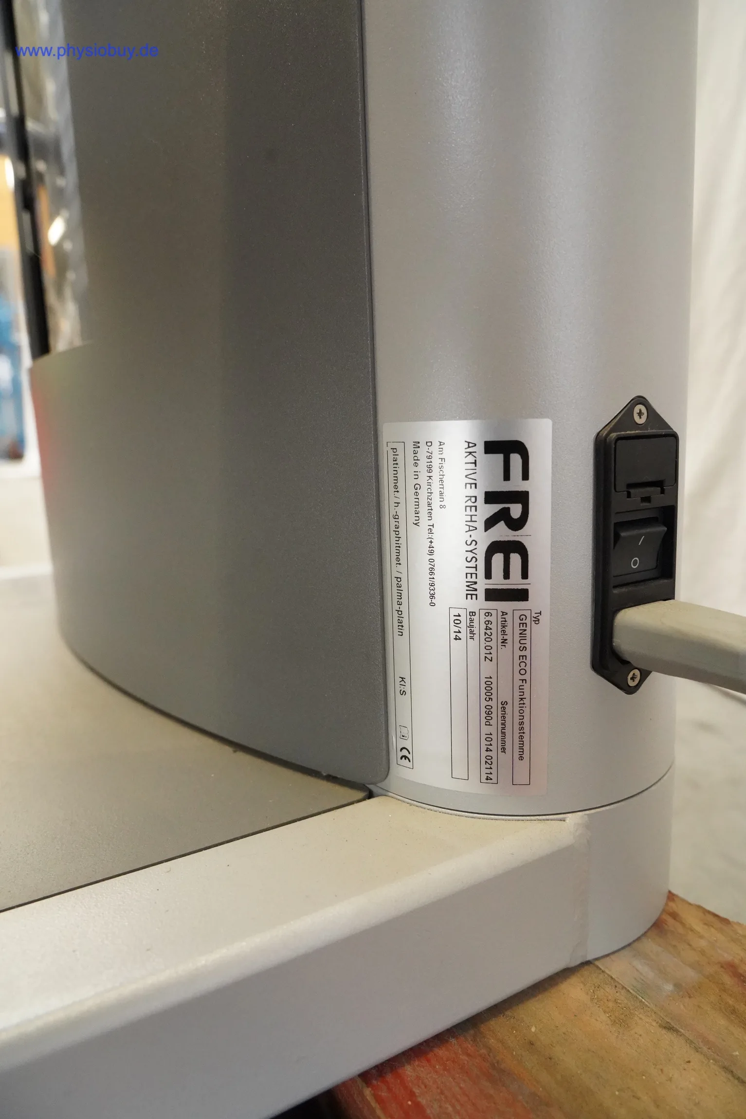 FREI Genius ECO: Typenschild am Standfuß neben Netzanschluss mit Kippschalter und angestecktem Kabel