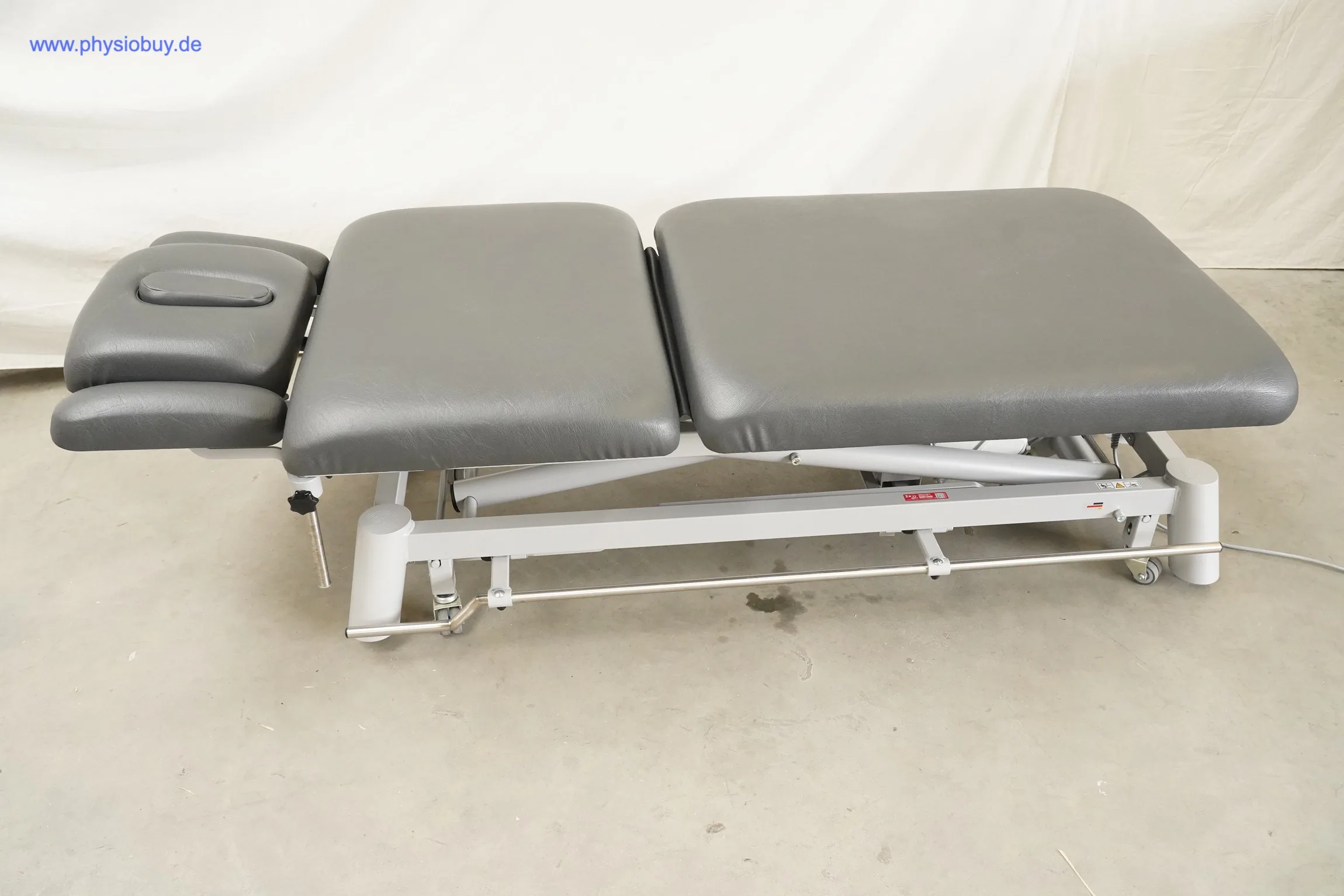 Pino XPert+ Therapieliege in grauem Polster, seitliche Gesamtansicht mit Kopfteil, Mittelteil und Sitzteil auf Hubgestell