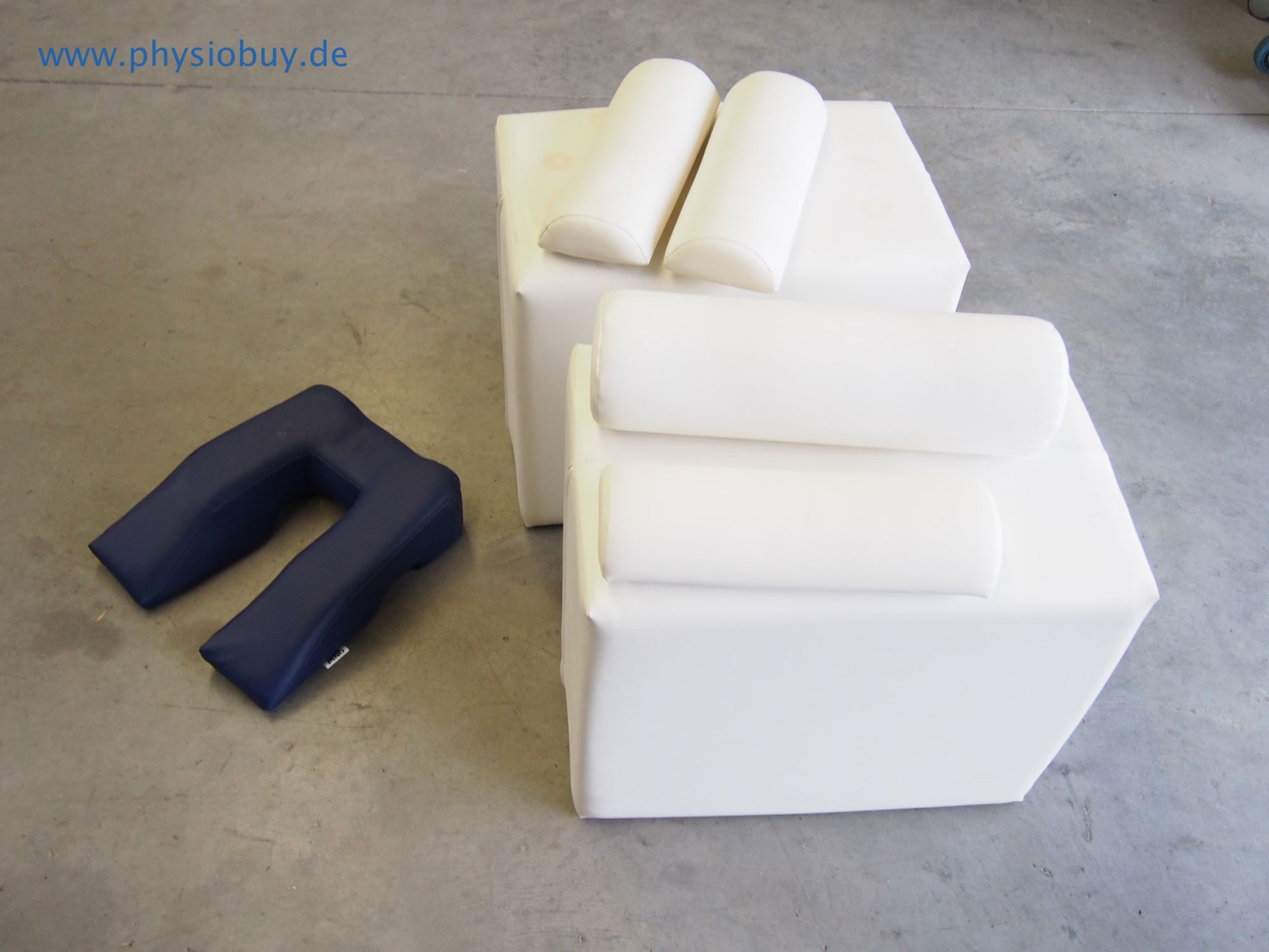Lagerungsmaterial-Set mit weißen Schaumstoffkeilen und dunkelblauer Nackenrolle