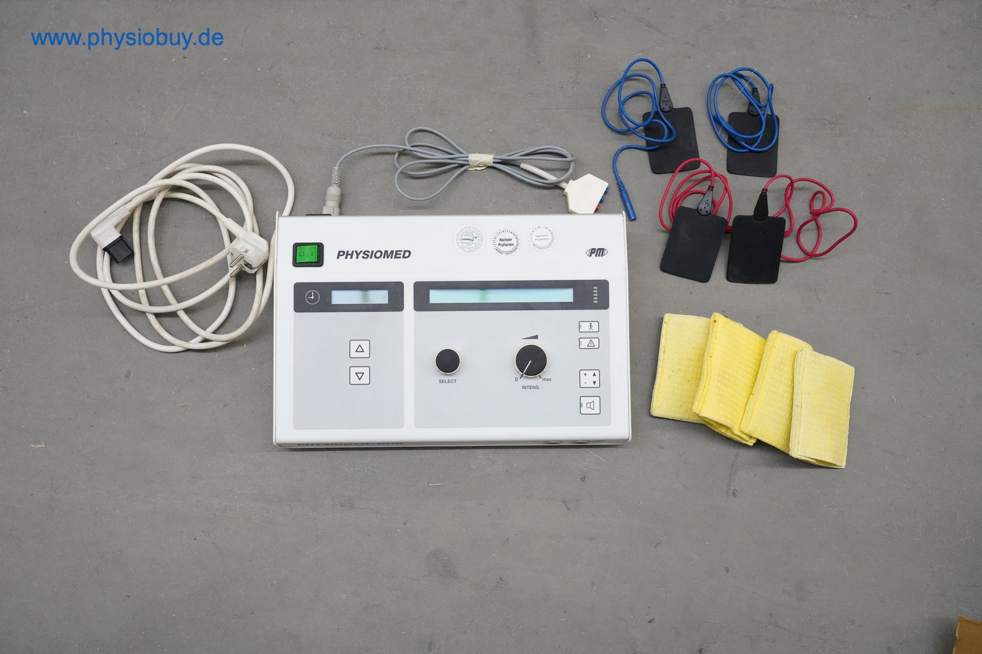 Elektrotherapiegerät Physiomed mit Kabeln, Klebeelektroden und gelben Fixiergurten