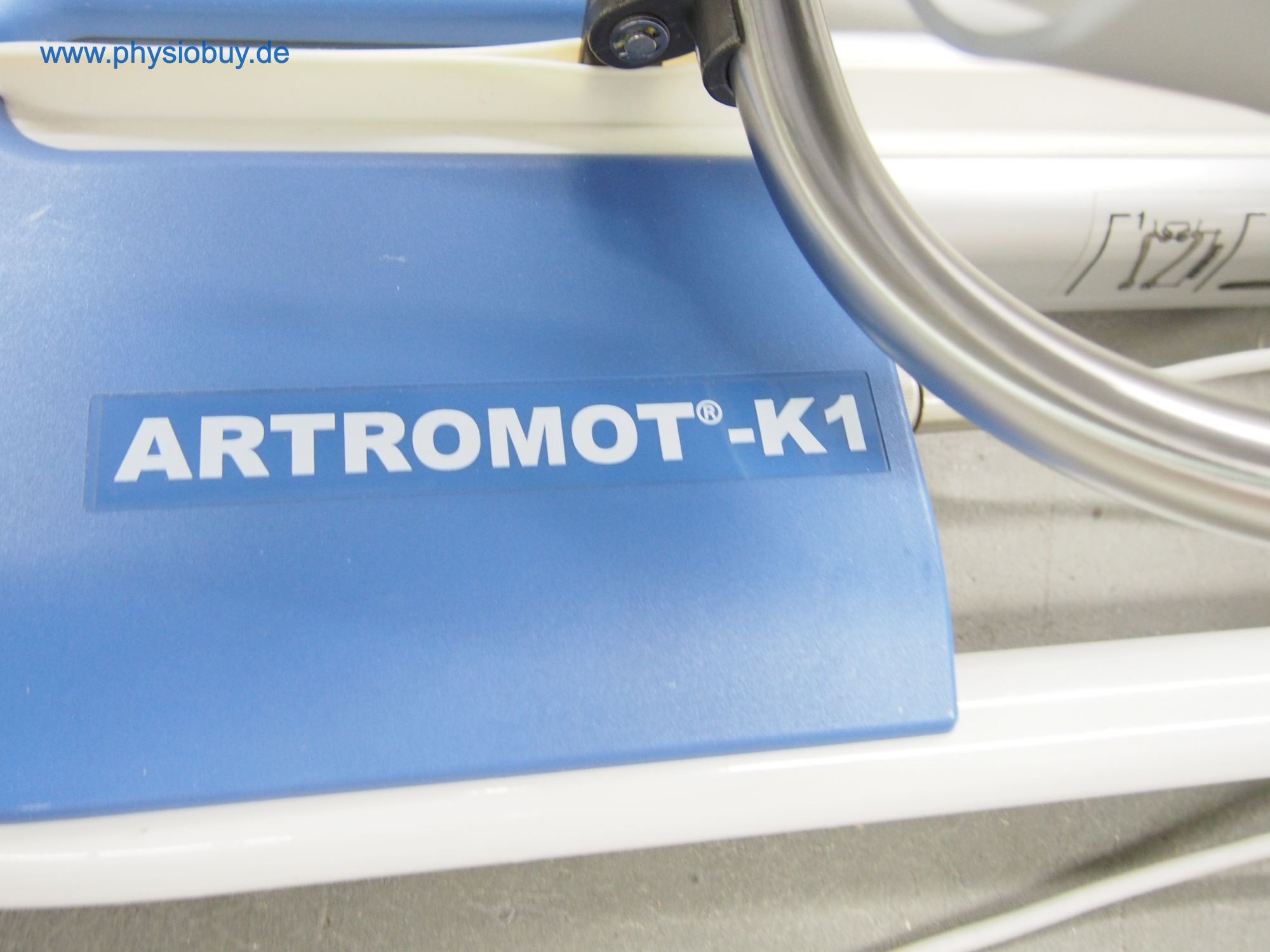 Typenschild „Artromot-K1 auf der blauen Abdeckung der Bewegungsschiene"
