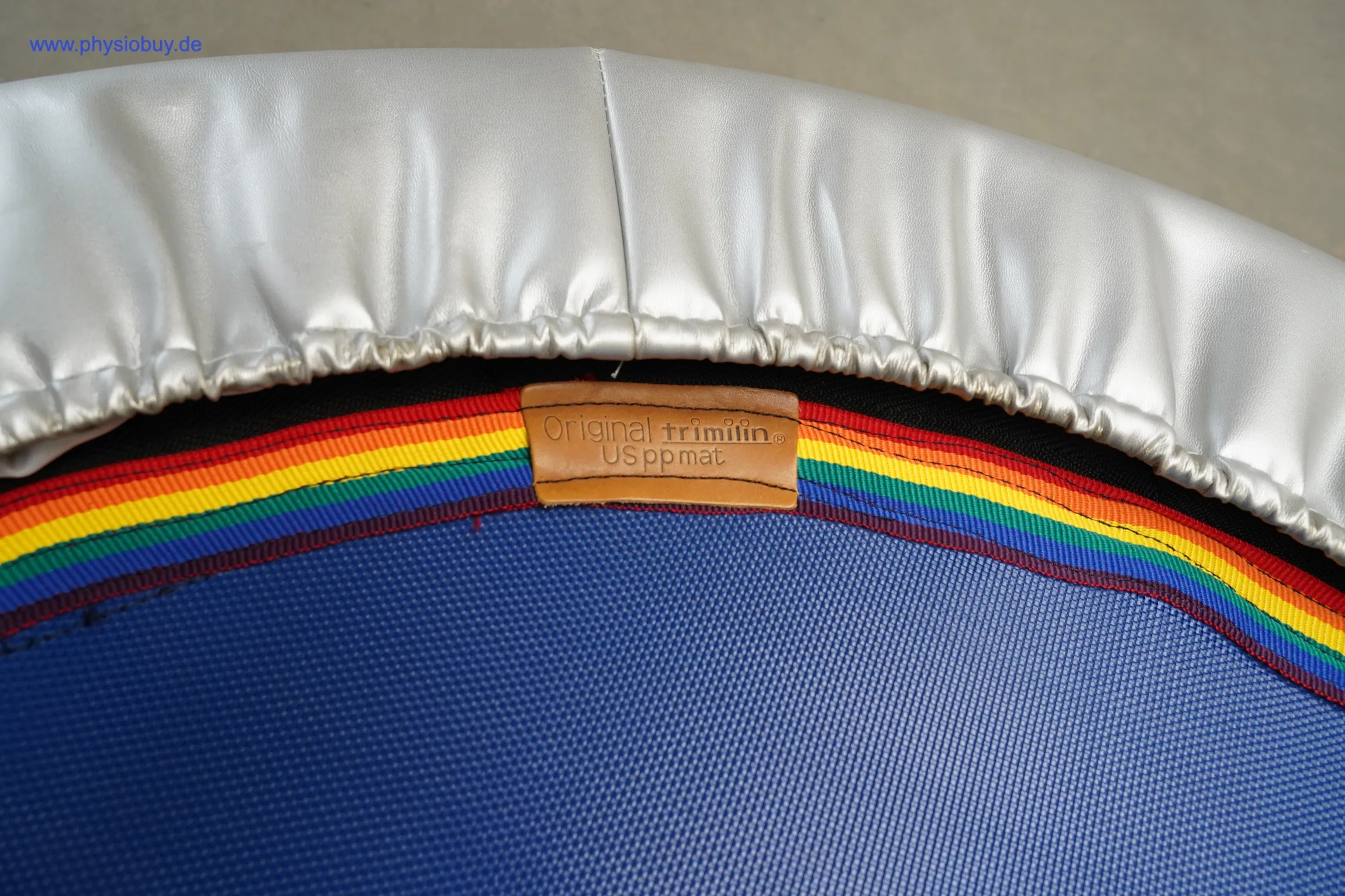 Mini-Trampolin, Nahaufnahme des Randes mit Regenbogenstreifen und Herstellerlabel