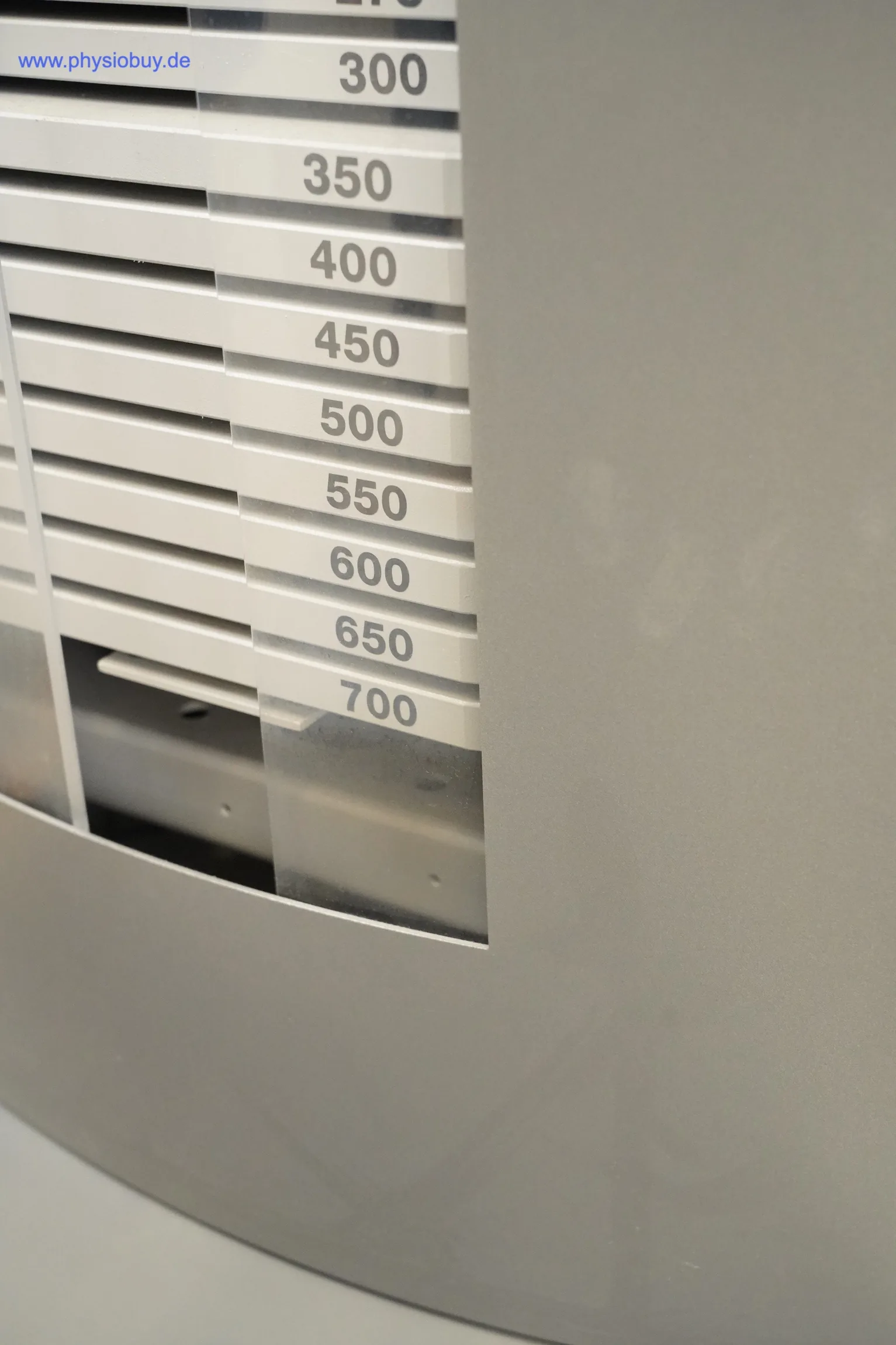 FREI Genius ECO: Gewichtsblock des Kraftgeräts mit Zahlenskala von 300 bis 700 im Ausschnitt der grauen Verkleidung