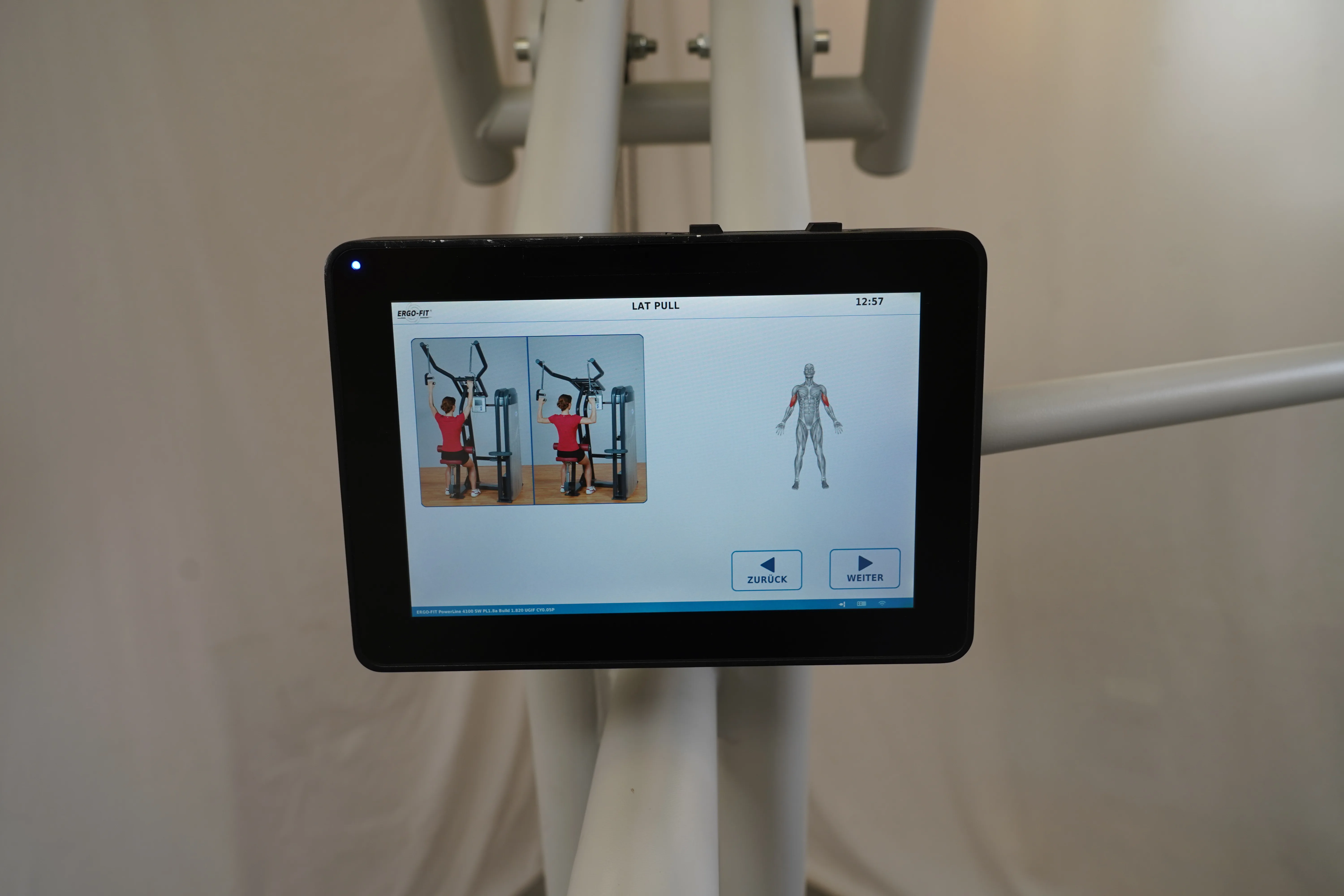 Touch-Display der Lat-Pull-Station am Ergo-Fit 4100S mit Übungsdarstellung und Navigationspfeilen