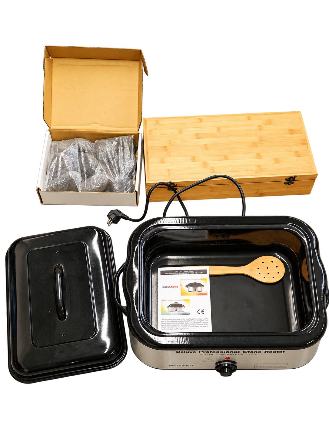 Hot Stone Erhitzer mit abgenommenem Deckel, Holzlöffel und Anleitung, daneben Karton mit Steinen und Bambusbox