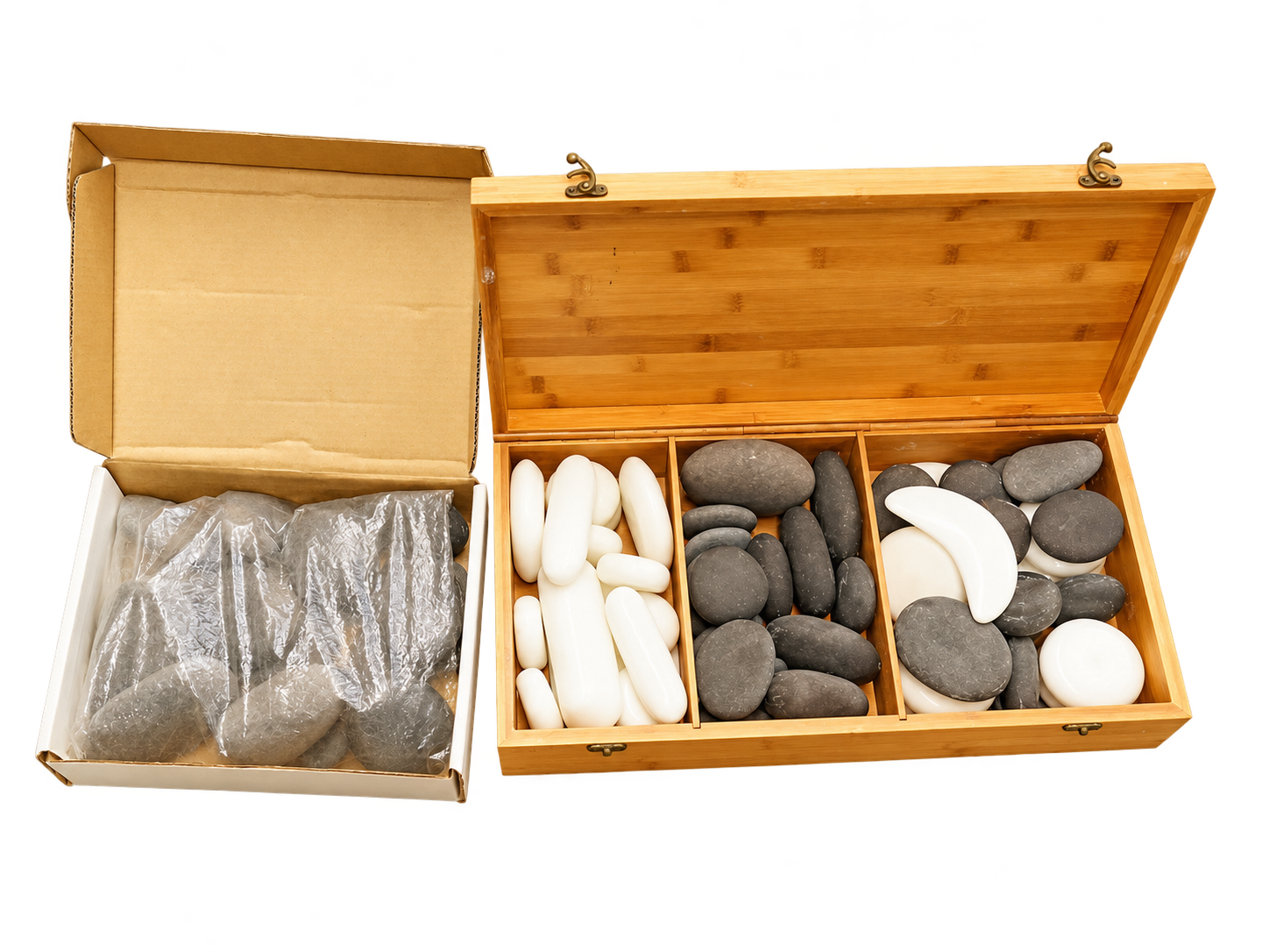 Hot-Stone-Set mit weißen und grauen Massagesteinen in geöffneter Holzbox, daneben ein Karton mit folienverpackten Steinen
