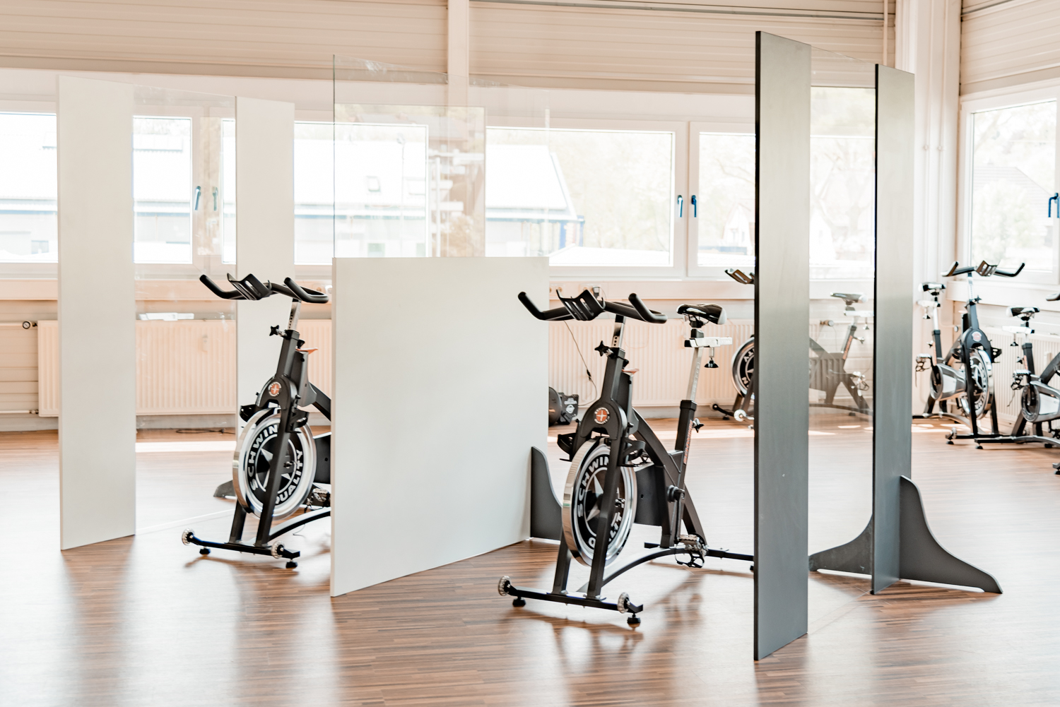 Trennwände Standard in Hell und Dunkel stehen zwischen mehreren Indoor-Cycles im Studio
