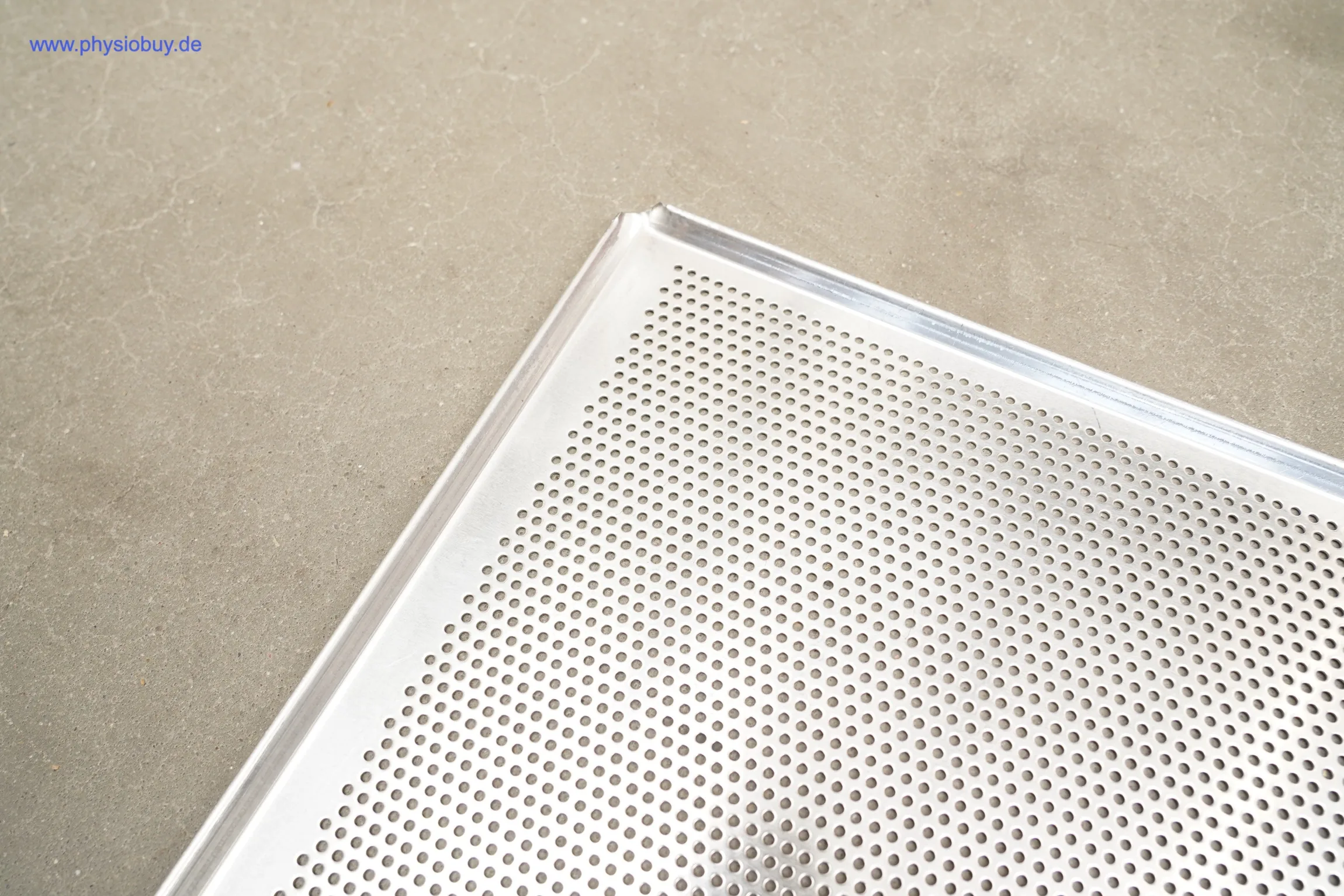 Ecke eines großen gelochten Warmhalteschrankblechs, Nahaufnahme