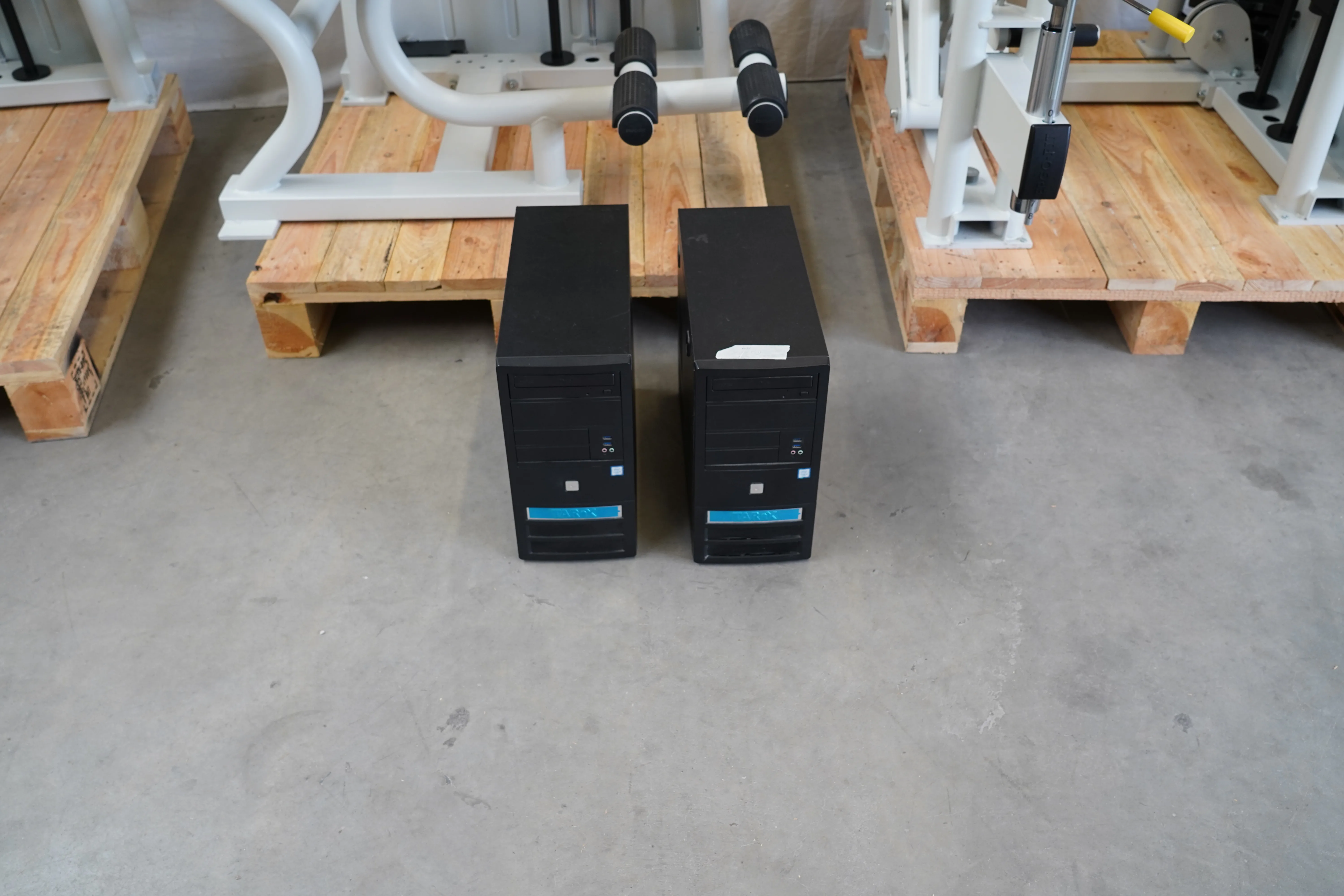 Zwei schwarze Gewichtsblock-Gehäuse am Boden vor weiteren Trainingsgeräten des Ergo-Fit-Gerätepark