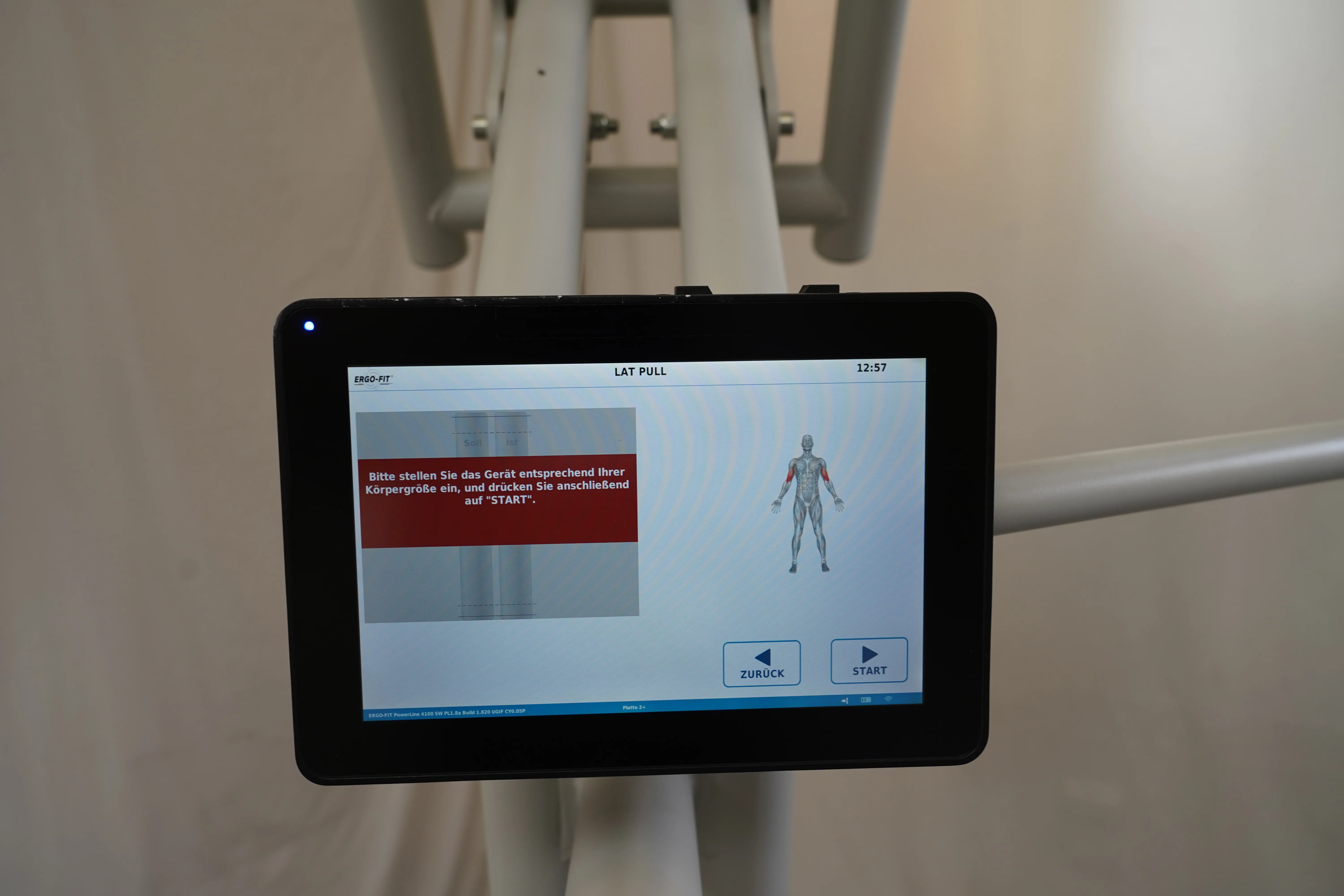 Touch-Display der Lat-Pull-Station am Ergo-Fit 4100S mit Hinweistext auf rotem Banner