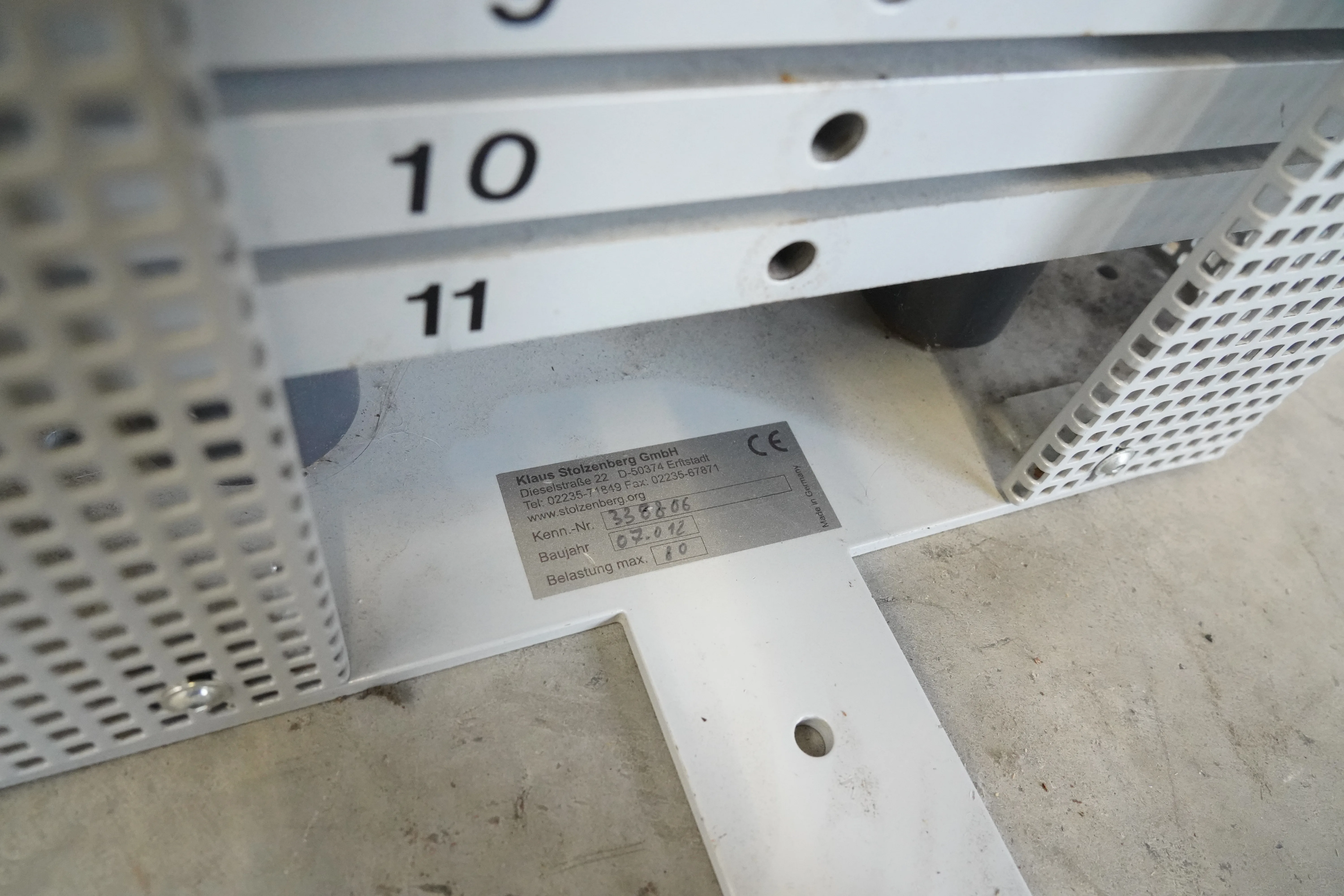 Stolzenberg Cable Cross Wandzugapparat: Typenschild mit CE-Zeichen am Fuß, daneben nummerierte Lochleisten