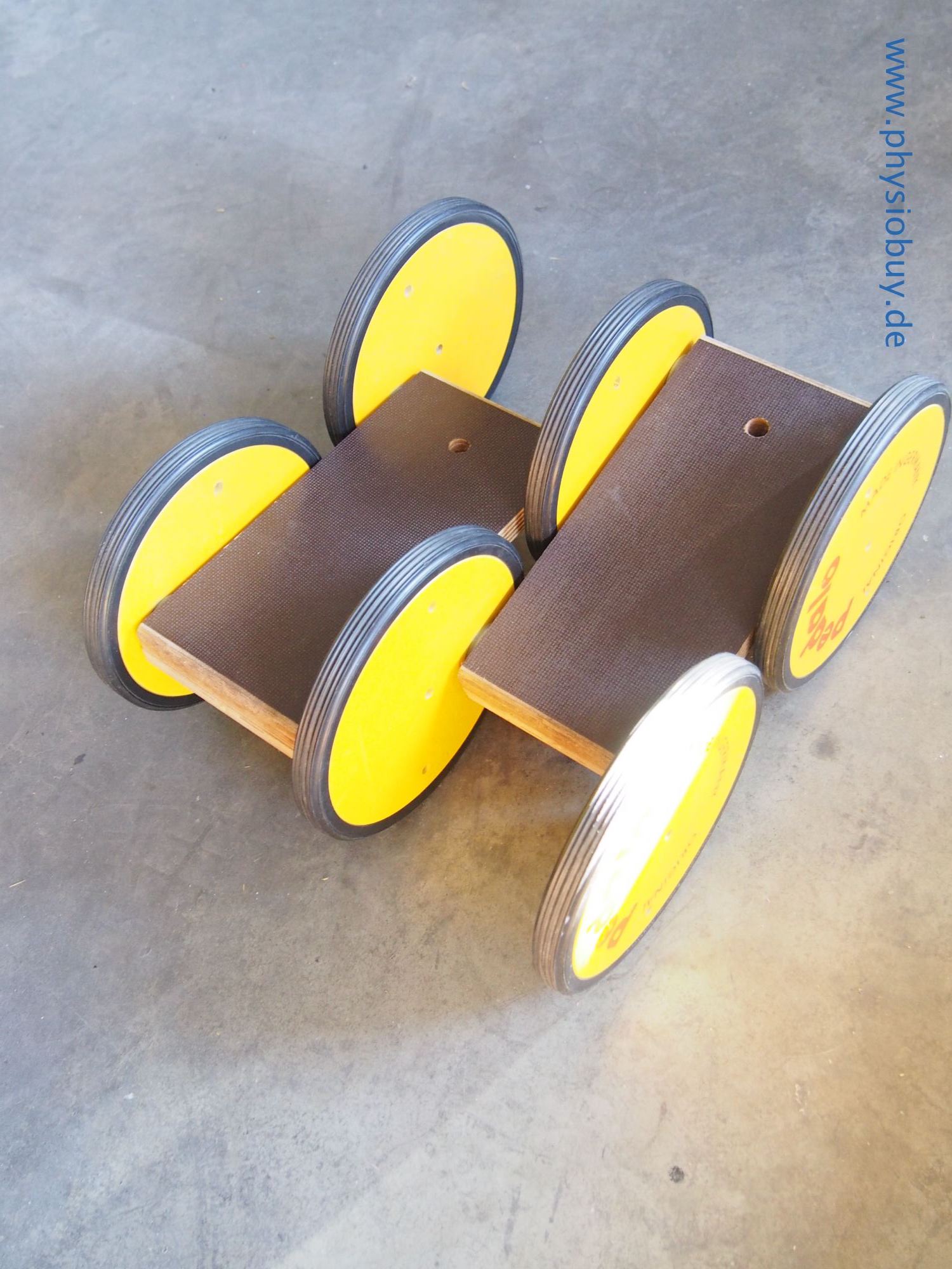 Zwei Pedalo-Classic-Balancetrainer mit gelben Rollen und Holzbrettern
