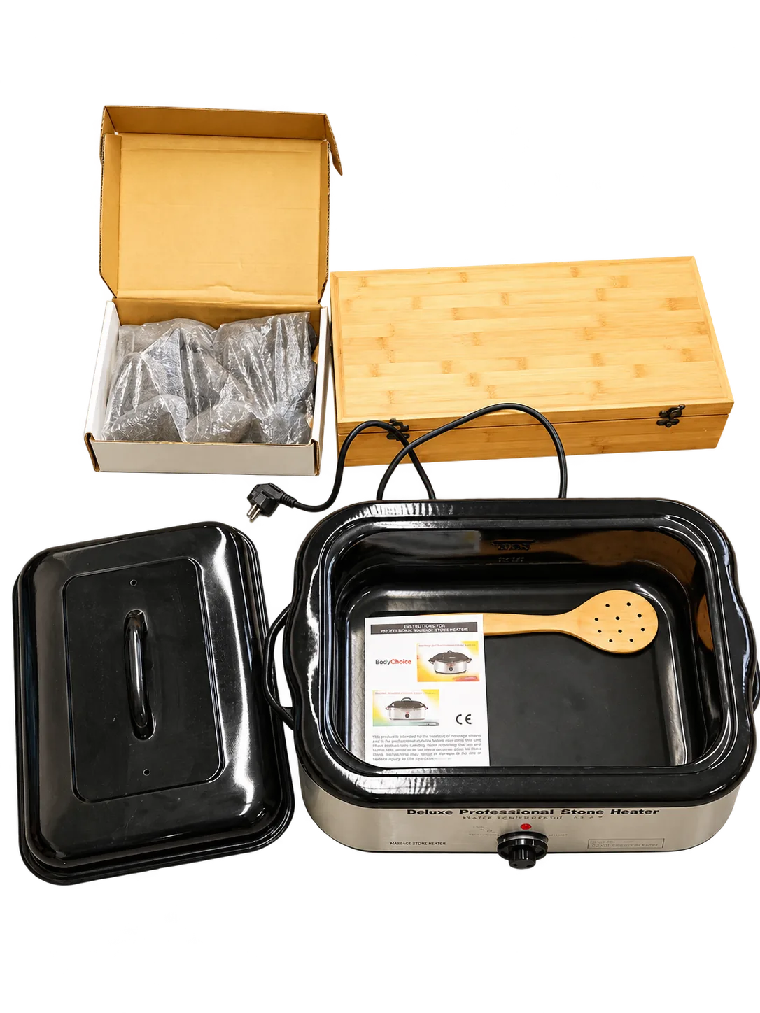 Hot Stone Erhitzer mit abgenommenem Deckel, Holzlöffel und Anleitung, daneben Karton mit Steinen und Bambusbox
