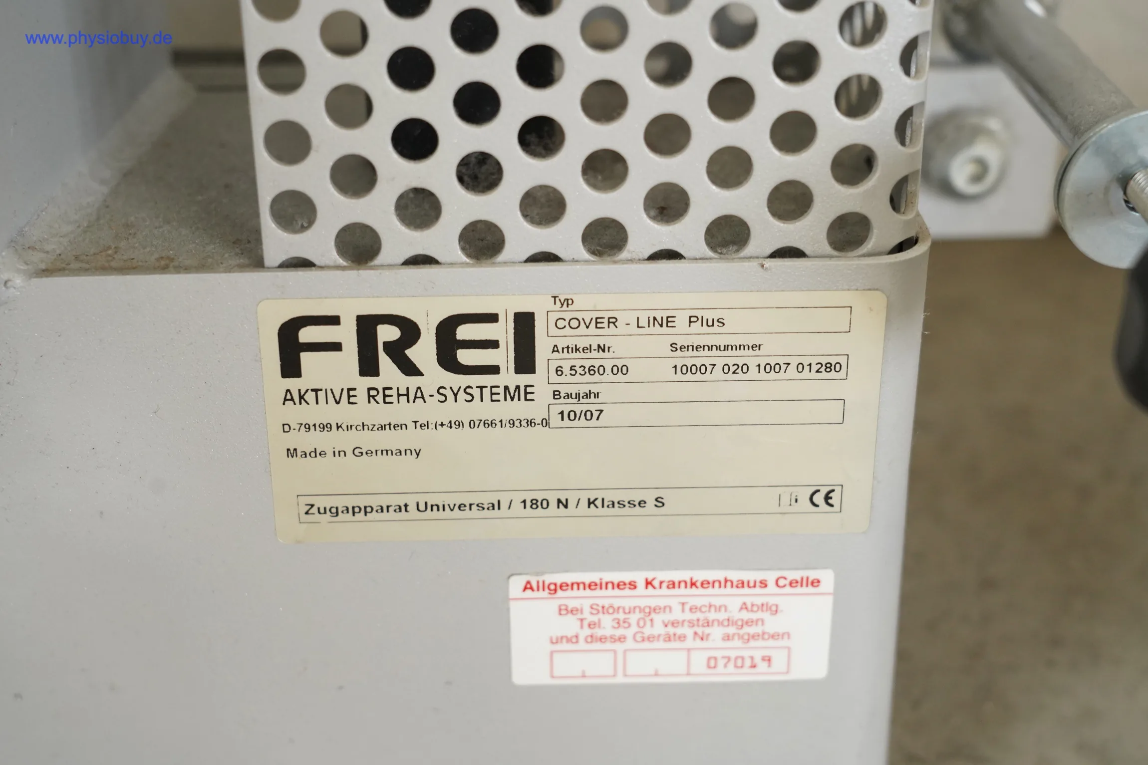 Typenschild am FREI Zugapparate Cover-Line Universal neben einem Lochblech, darunter ein Aufkleber des Krankenhauses Celle