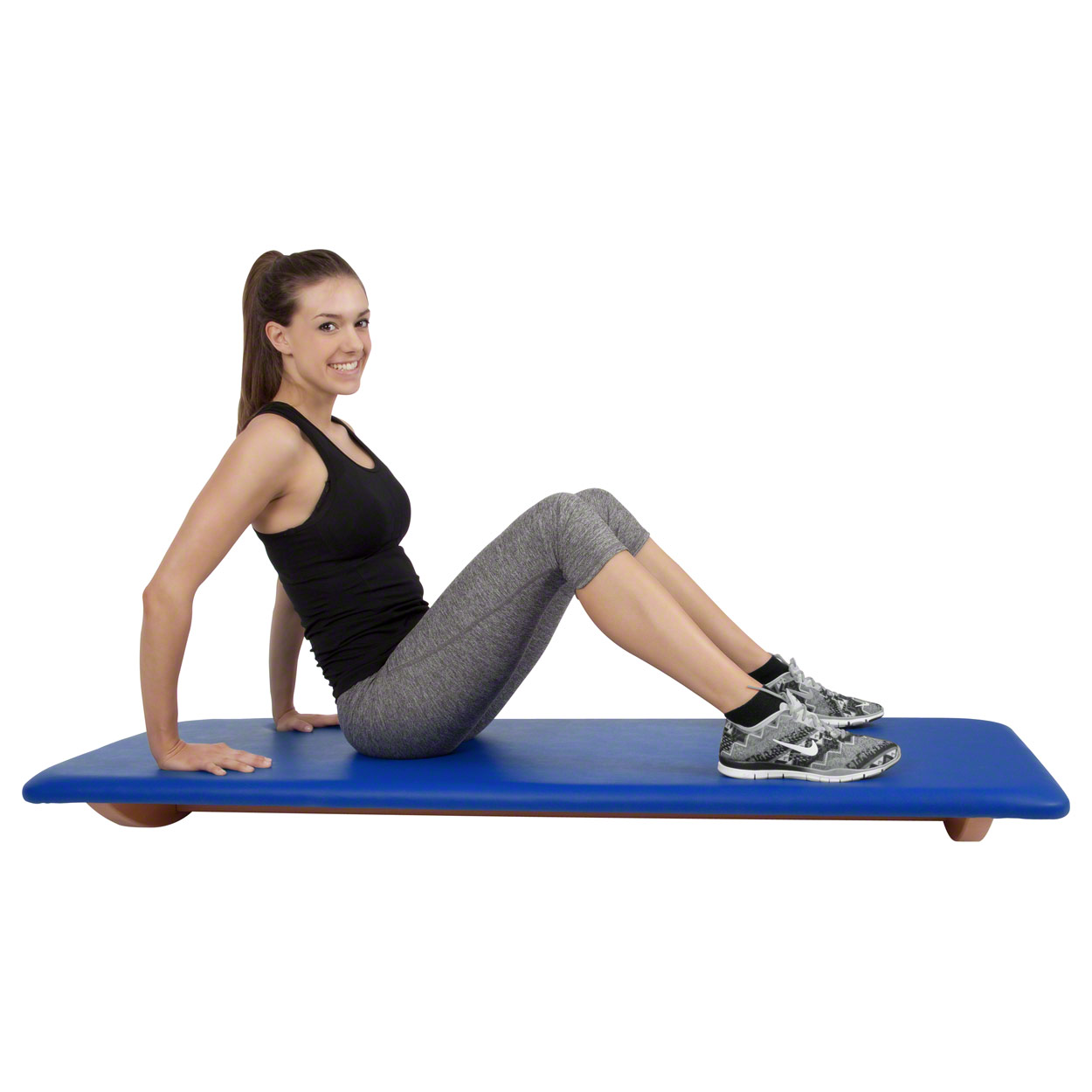 Frau macht Sit-ups auf dem gepolsterten Schaukelbrett in Blau