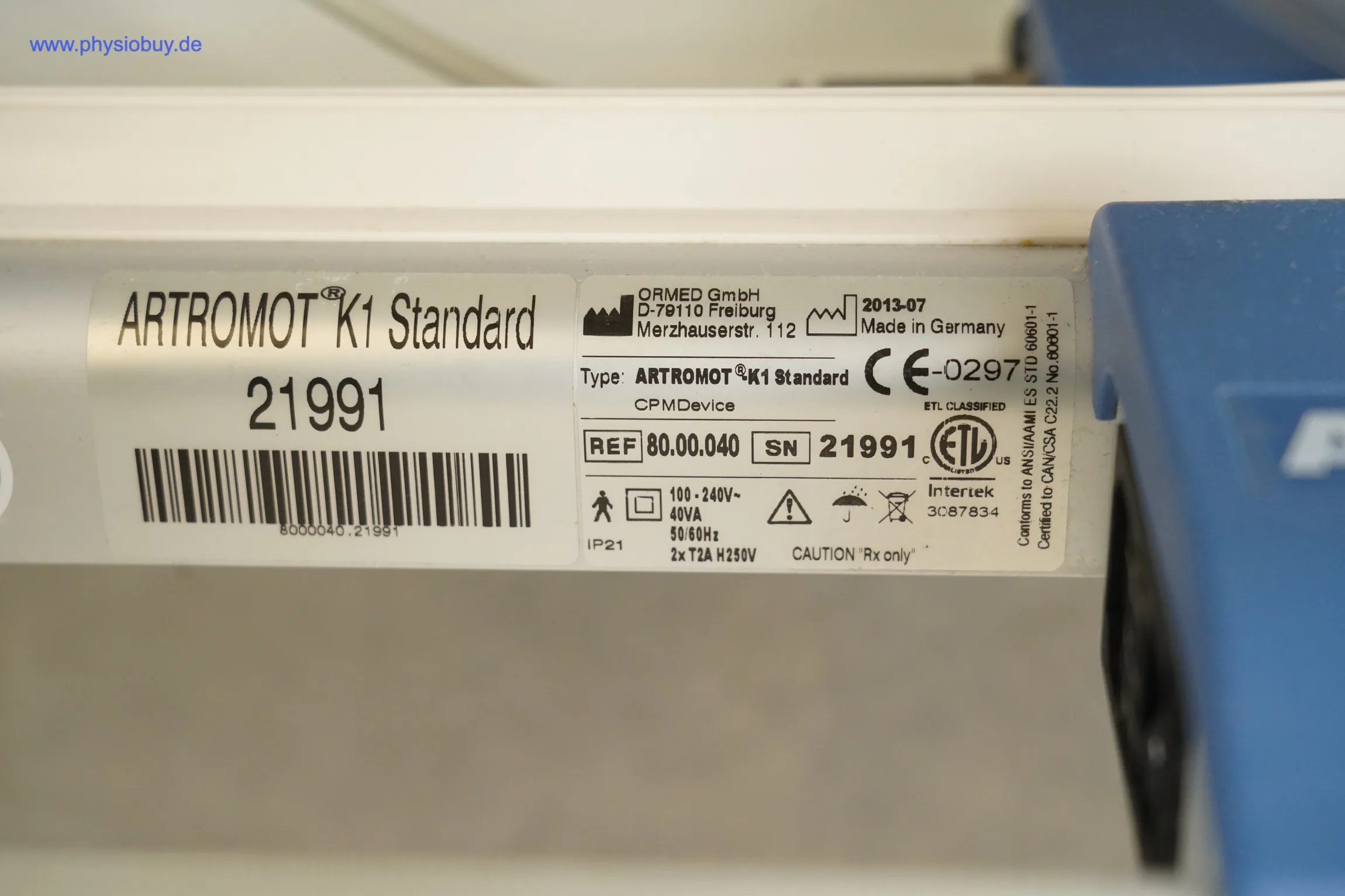 Typenschild und Etikett der Artromot K1 Standard Bewegungsschiene mit Seriennummer 21991 und Barcode