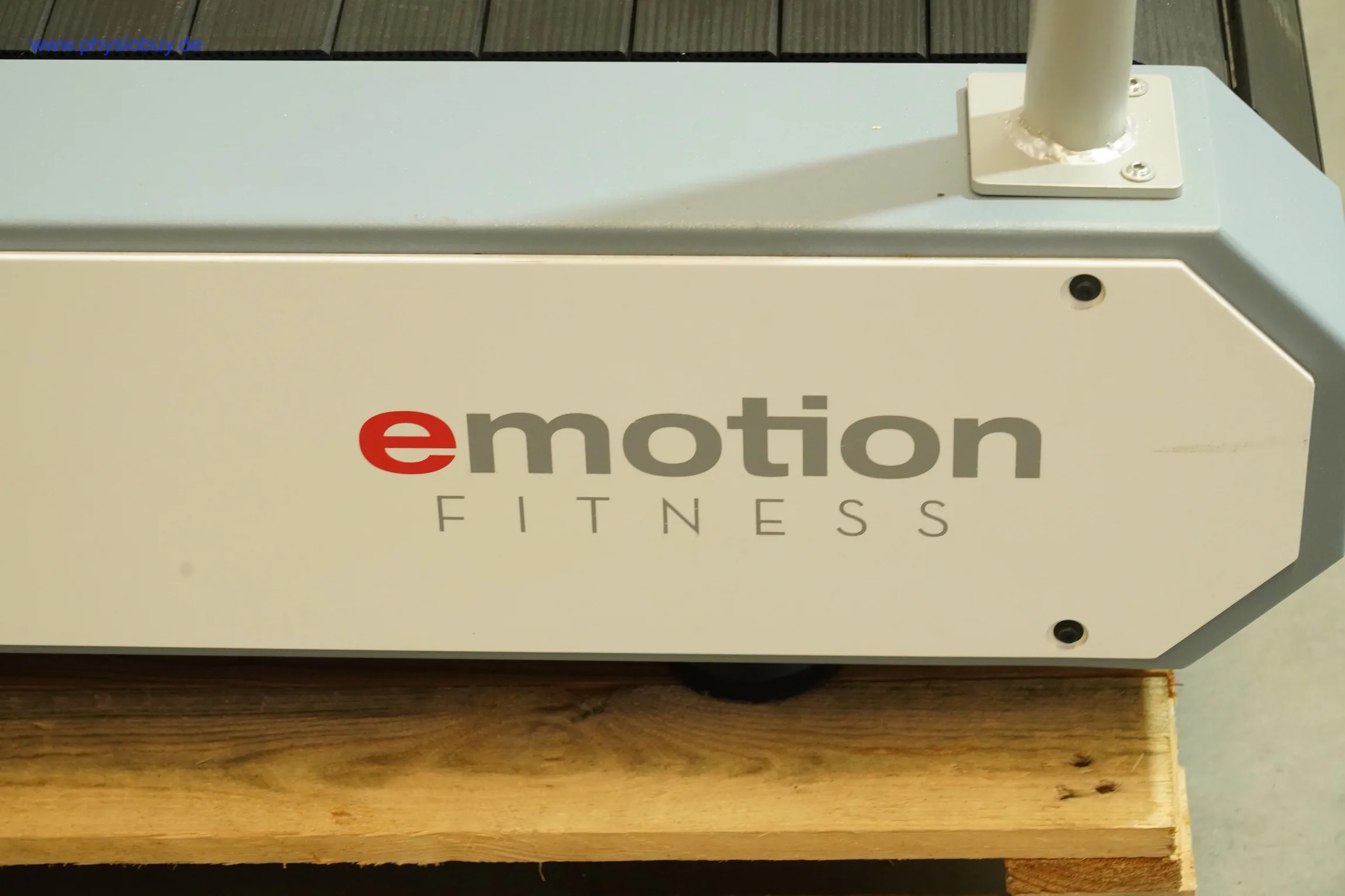 Logo „emotion FITNESS“ an der Seitenverkleidung des Laufbands auf Palette