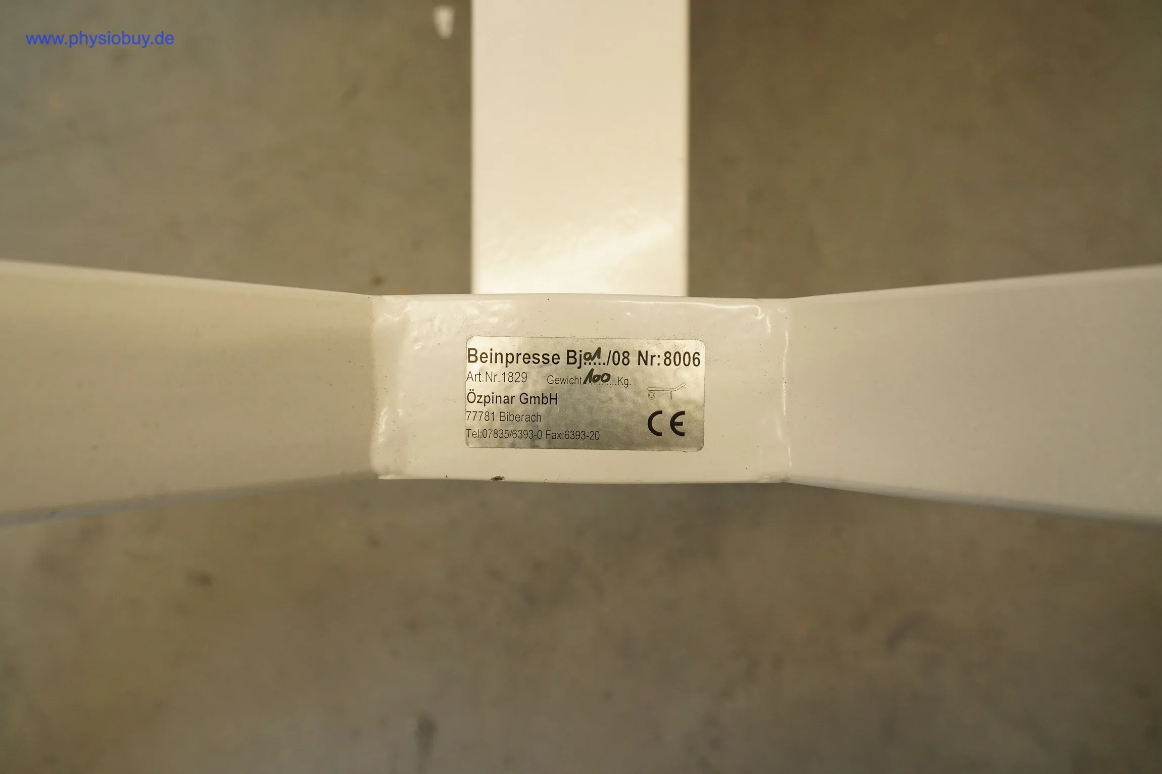 Typenschild mit CE-Zeichen am weißen Rahmen der Özpinar Funktionsstemme, Draufsicht auf Betonboden